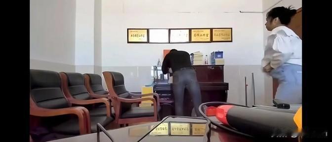 这俩人在办公室里那点事儿，被拍了个正着。从照片看，办公环境真心一般，墙上挂着