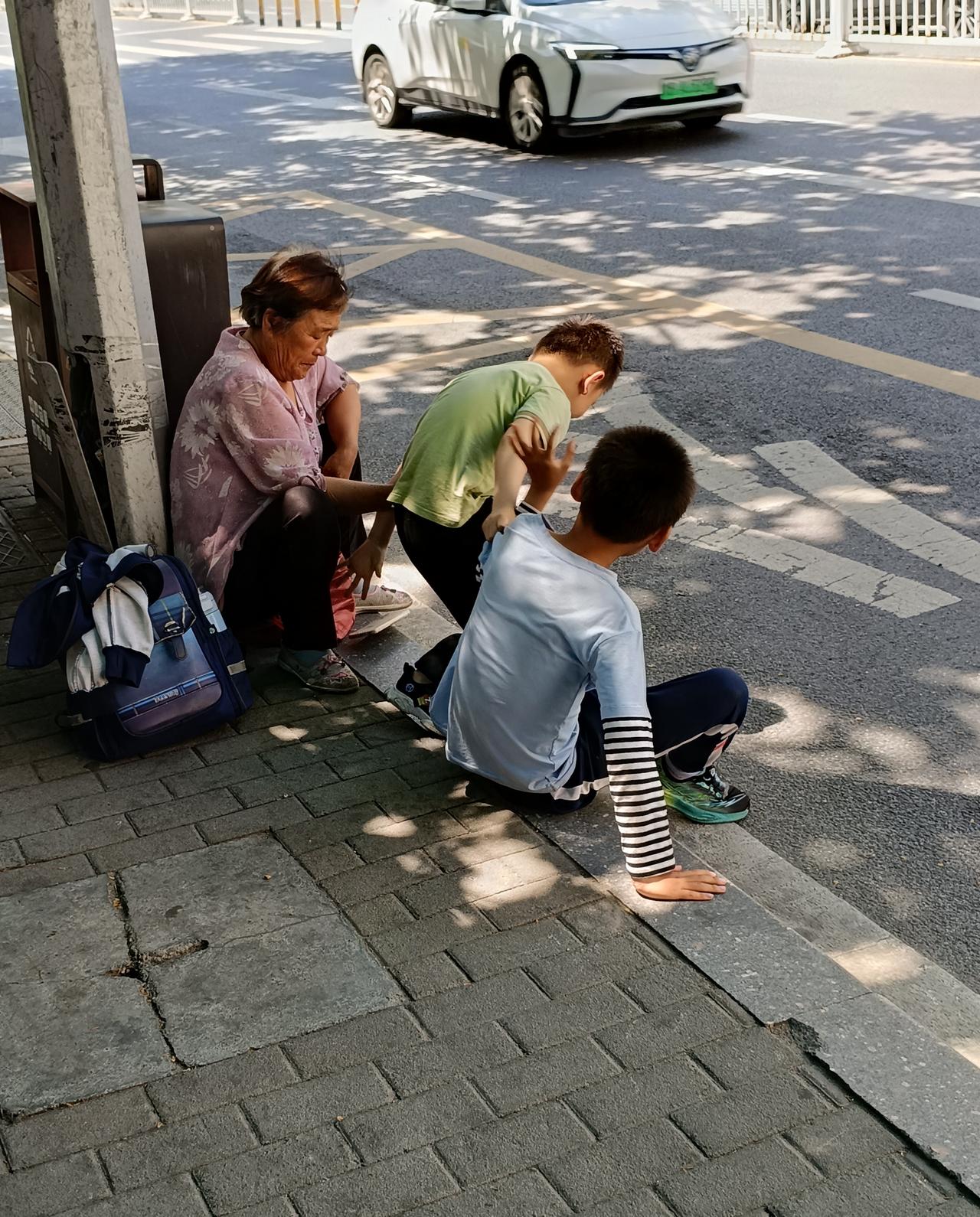 买菜回来在公交车站等车，车站上一个年长者领着两个男孩，两个男孩太调皮了，不停的打