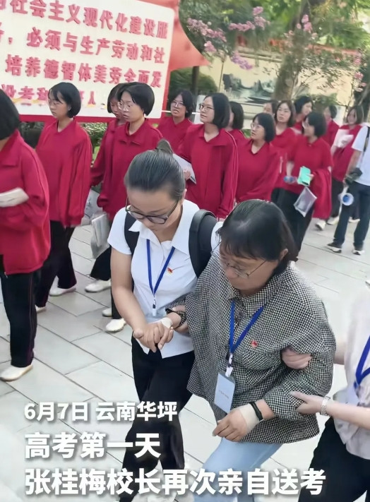 今年送考的张桂梅老师与往年大不一样之前她靠别人就行，但今年她的身边有两个搀扶