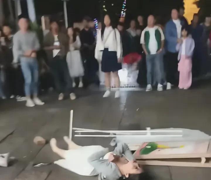 官渡古镇一女孩癫痫犯了，摔倒在地，身体不停的抽搐，很多人围了过来，却无一人去将女