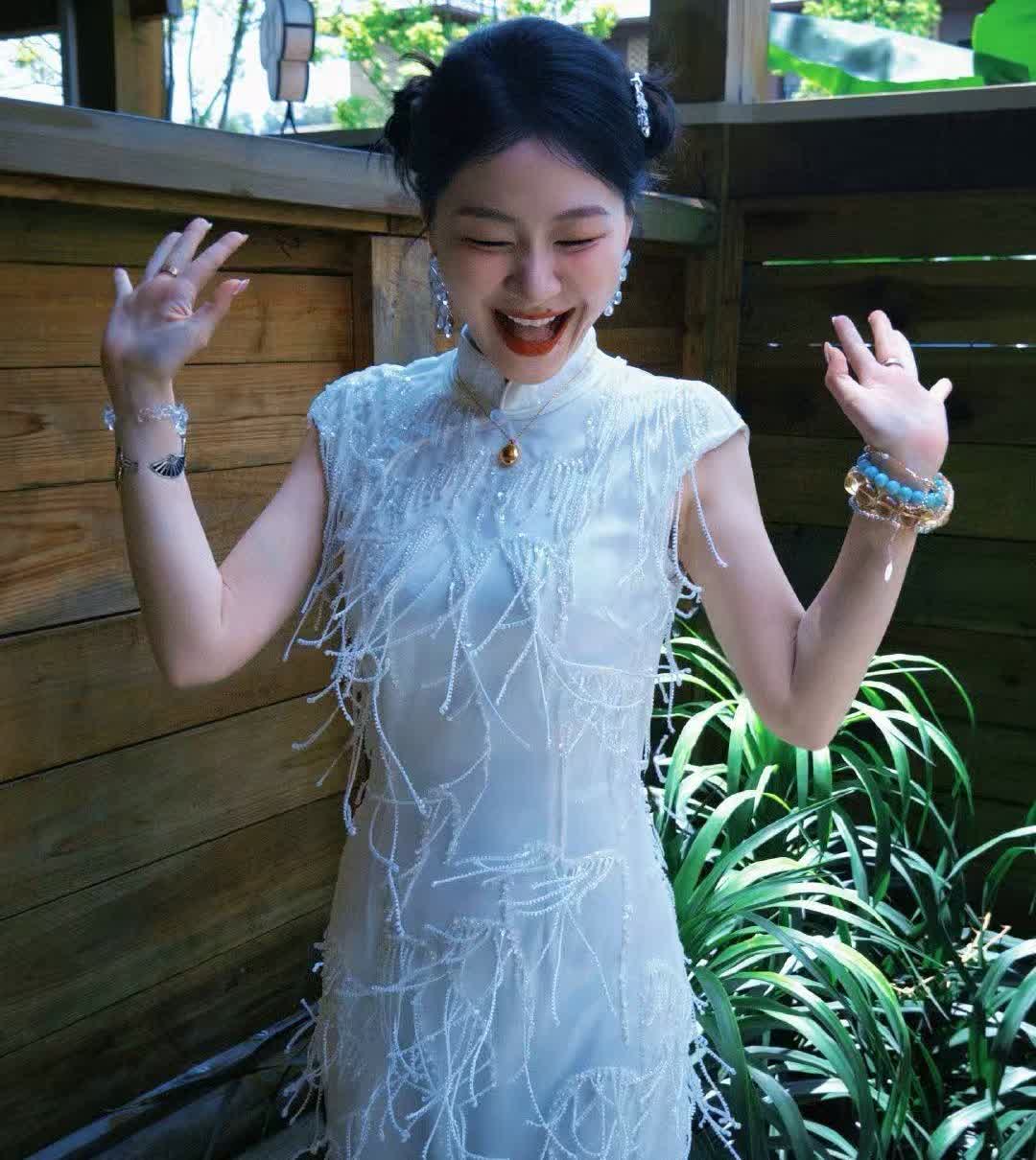 金靖穿白旗袍配碎钻流苏，往绿植边一站笑到发光✨发髻簪子、手腕串珠全是复古小