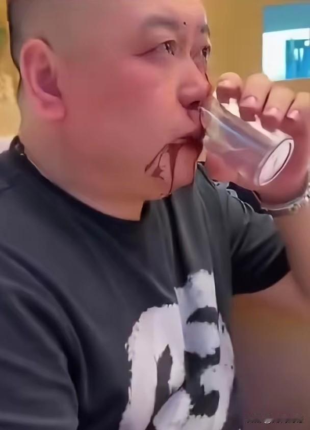 不知道这是演戏中的桥段，还是现实生活中真实发生的画面，这个端杯饮酒的男子，嘴角突