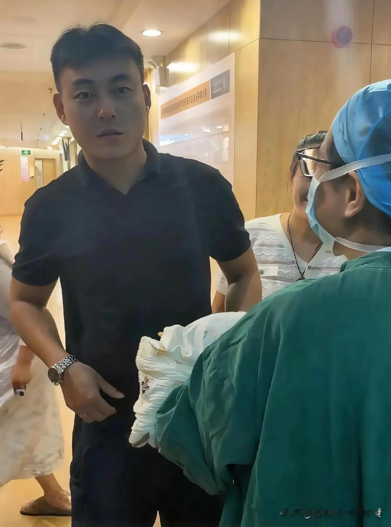 护士抱刚出生的宝宝出产房，让孩子爸爸猜性别，爸爸敷衍说“不知道”，眼睛一直望向手