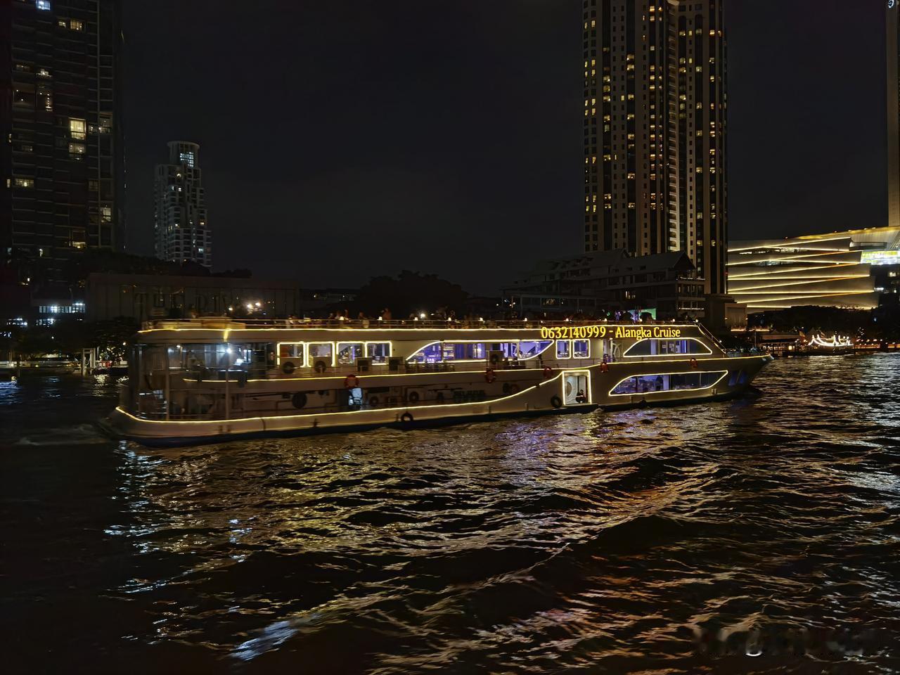 夜色笼罩湄南河，河面波光粼粼，游船周身环绕着绚丽霓虹，光影倒映在河水之中，随着波