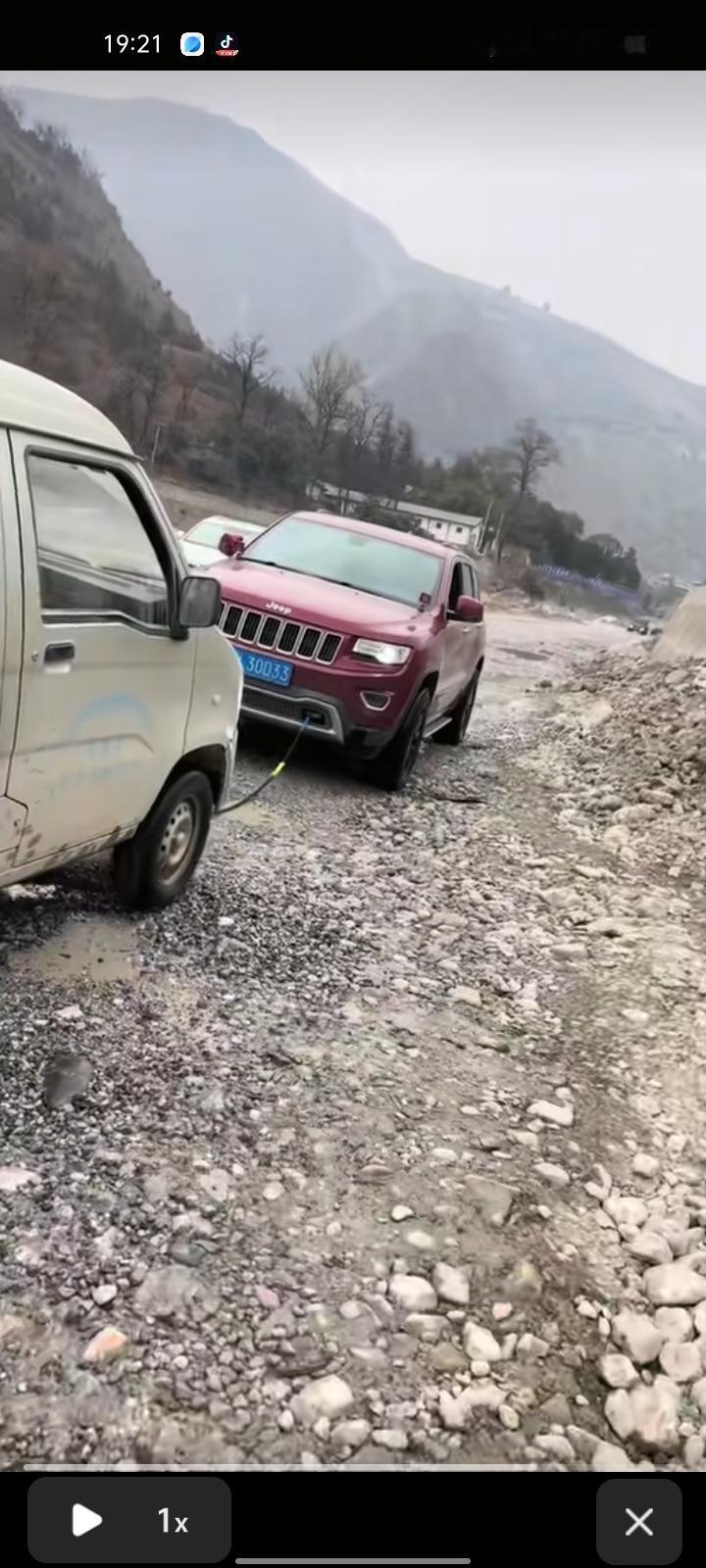 1月4日，甘肃陇南。面包车陷入河滩里几小时动弹不得，司机在冷水里刨石头十分无助。