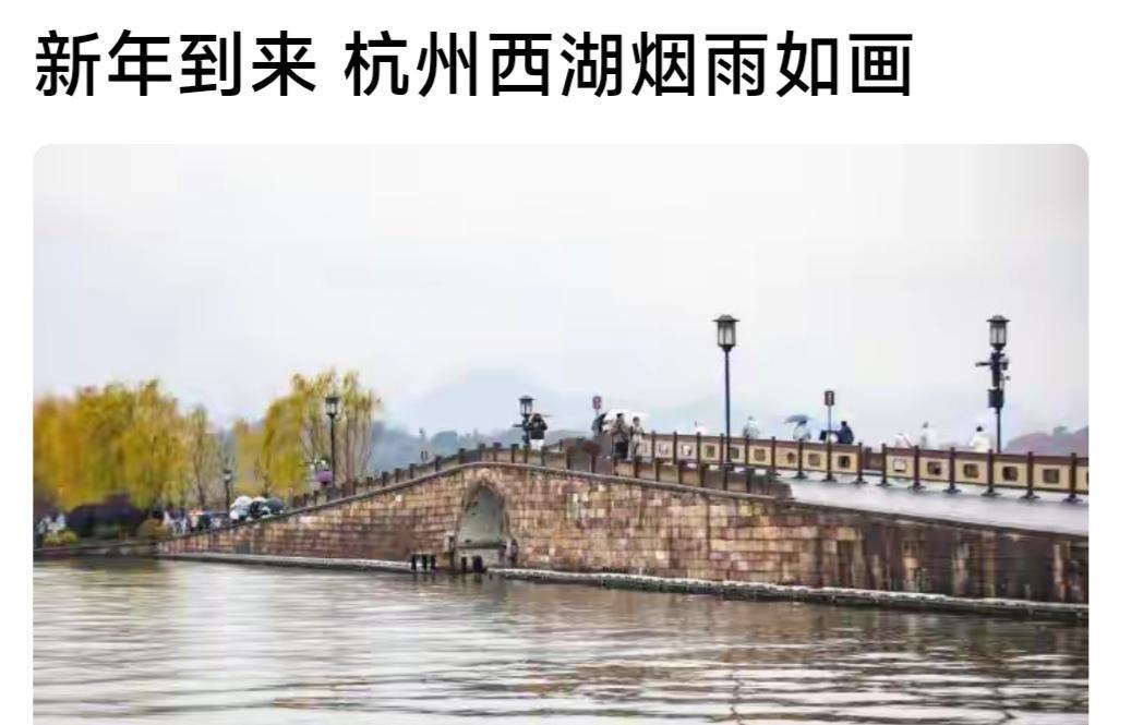 新年刚到，西湖就迎来了2026年的第一场烟雨。断桥上，游客们撑着伞慢慢走着，平