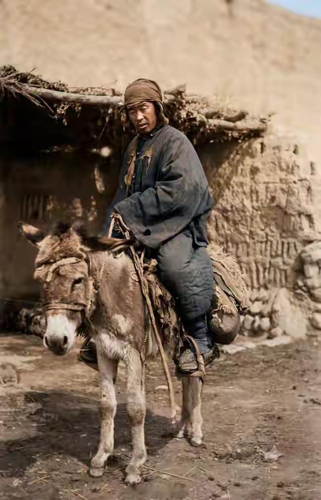 1908年，天津。乡间土坯屋前，裹着头巾的邮差下乡送邮驿。晚清“吃皇粮”的邮差混