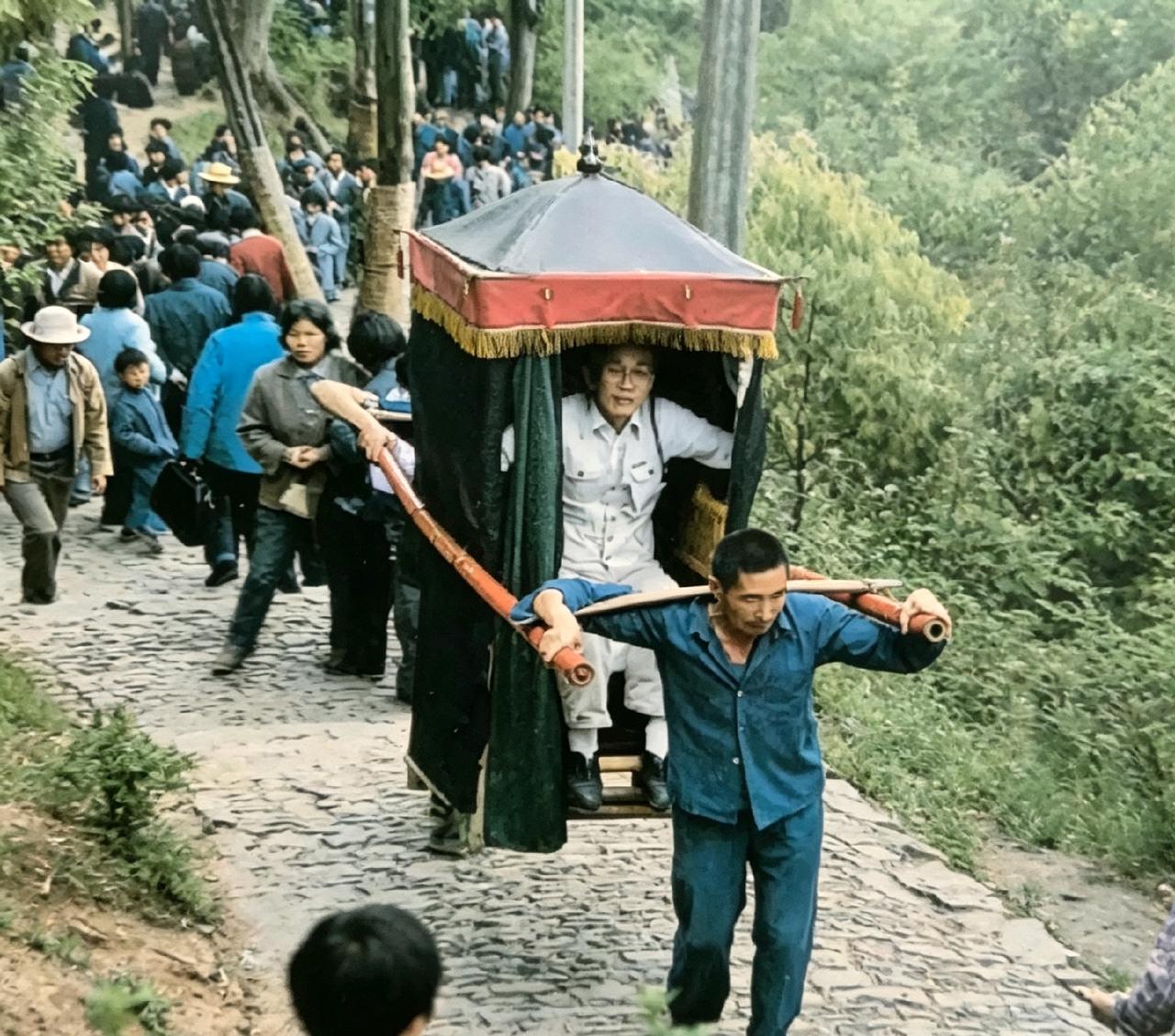 翻看这张老照片，心中感慨良多。早年登狼山并无缆车，滑竿便是上山的代步选择。轿夫踏
