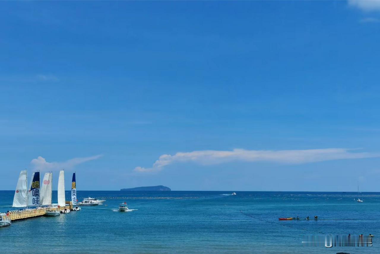 海边的沙滩金黄细腻，人们穿着清凉的泳衣，有的在踏浪，有的在堆沙堡。海浪一波接着一