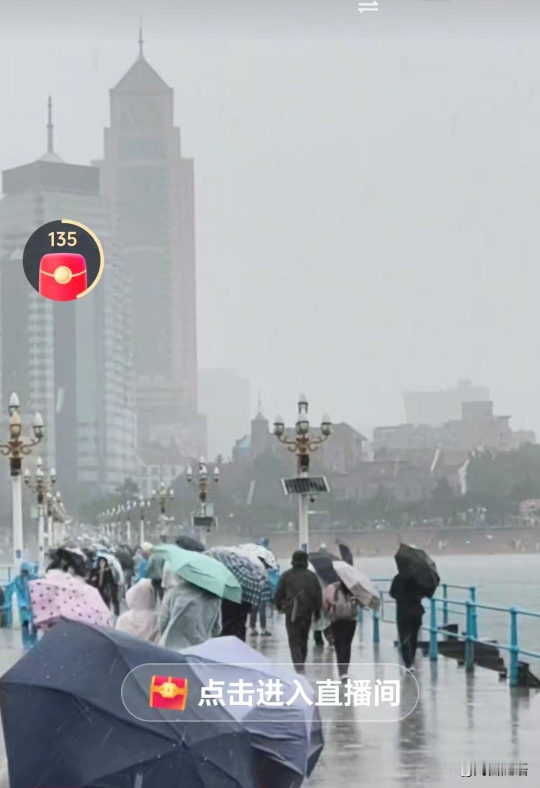 来青岛旅游的人没想到，大海不用看，天天赏雨了，瞧瞧海边游客，顶风冒雨的玩！估计