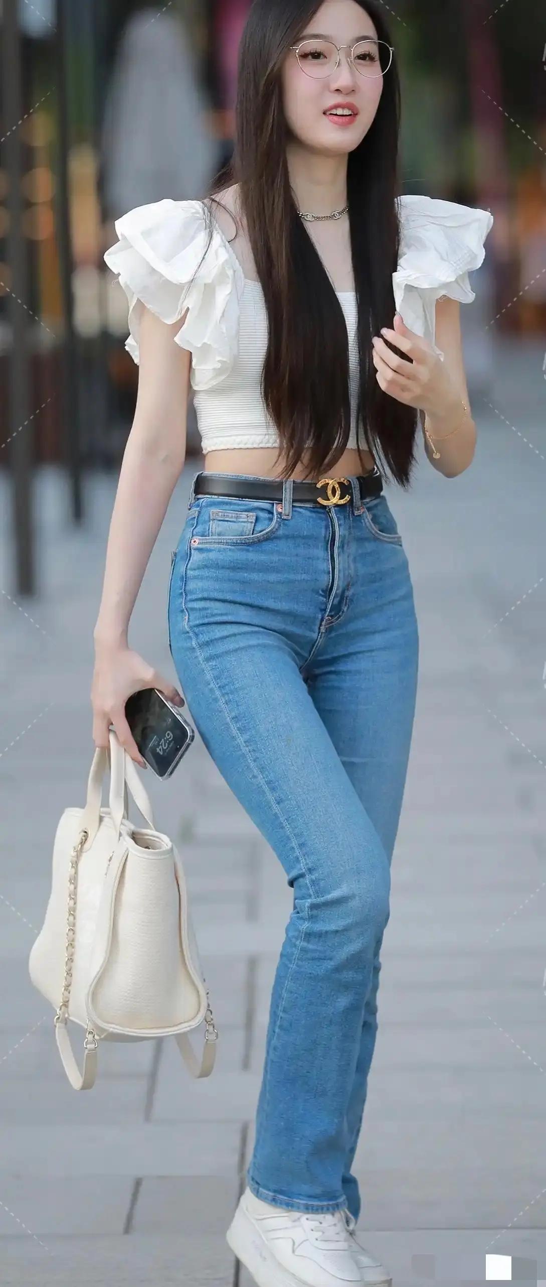 穿着紧身牛仔裤的眼镜妹走在大街上，成为一道靓丽的风景！牛仔裤美照穿搭街拍好