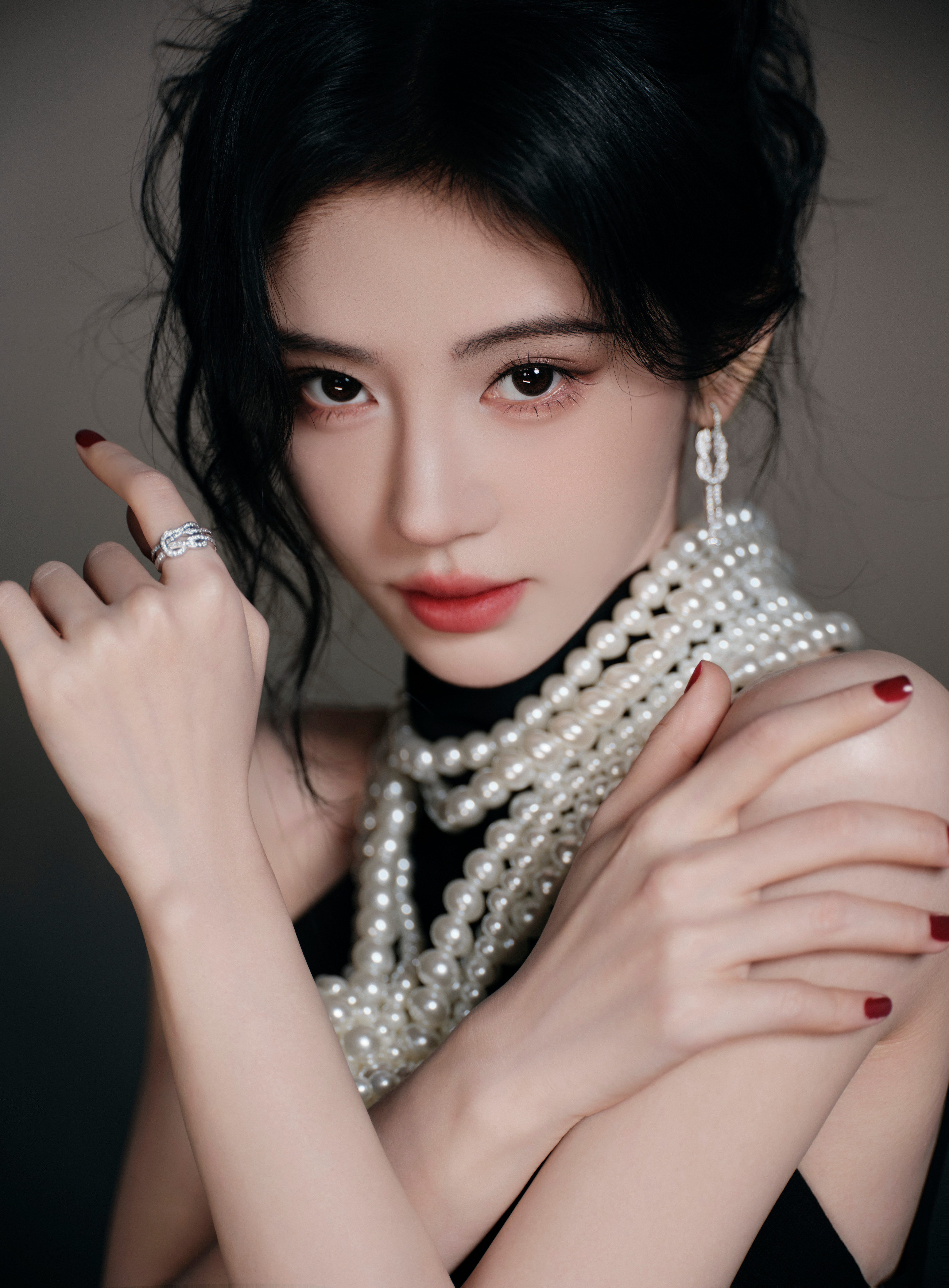 鞠婧祎黑缎礼裙裹着玲珑身段，珍珠缠颈勾勒出柔润的轮廓，优雅与媚态揉成了暗夜最撩