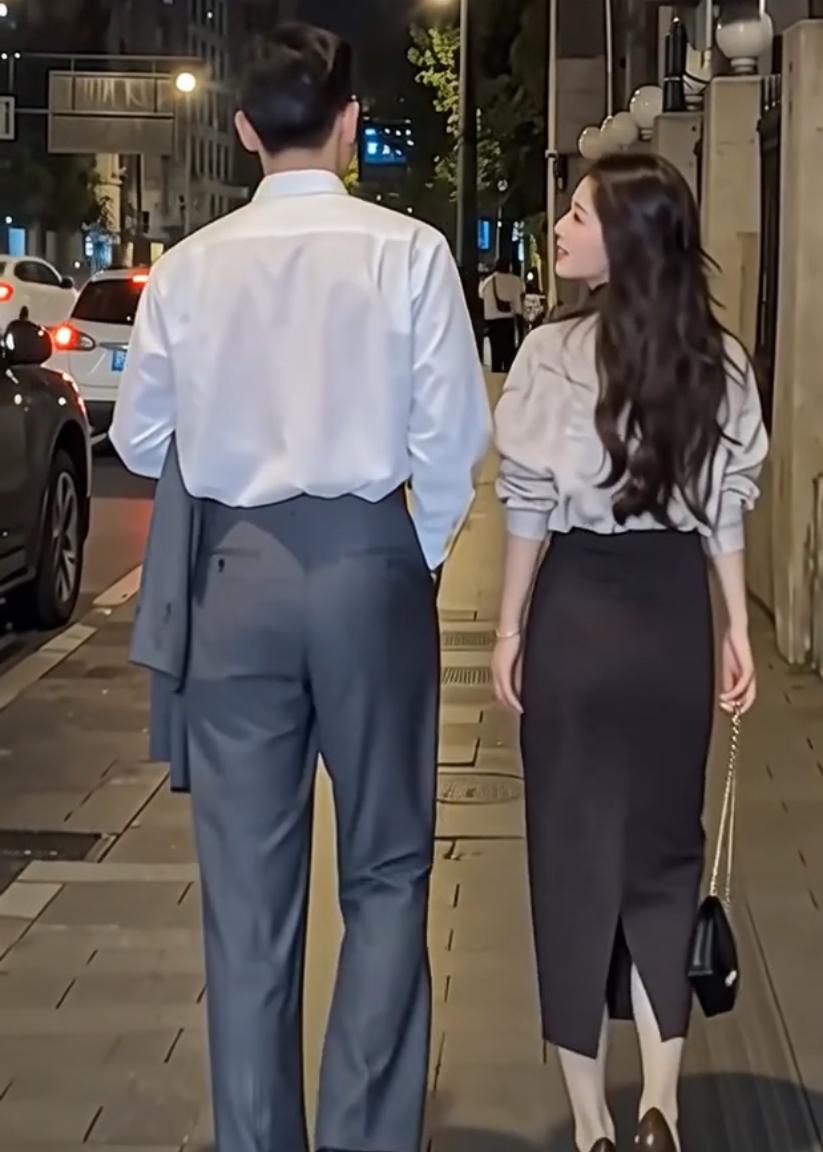 夜色下的浪漫漫步，情侣牵手同行，尽显温馨。他们的脚步轻盈而缓慢，仿佛时间也为这份