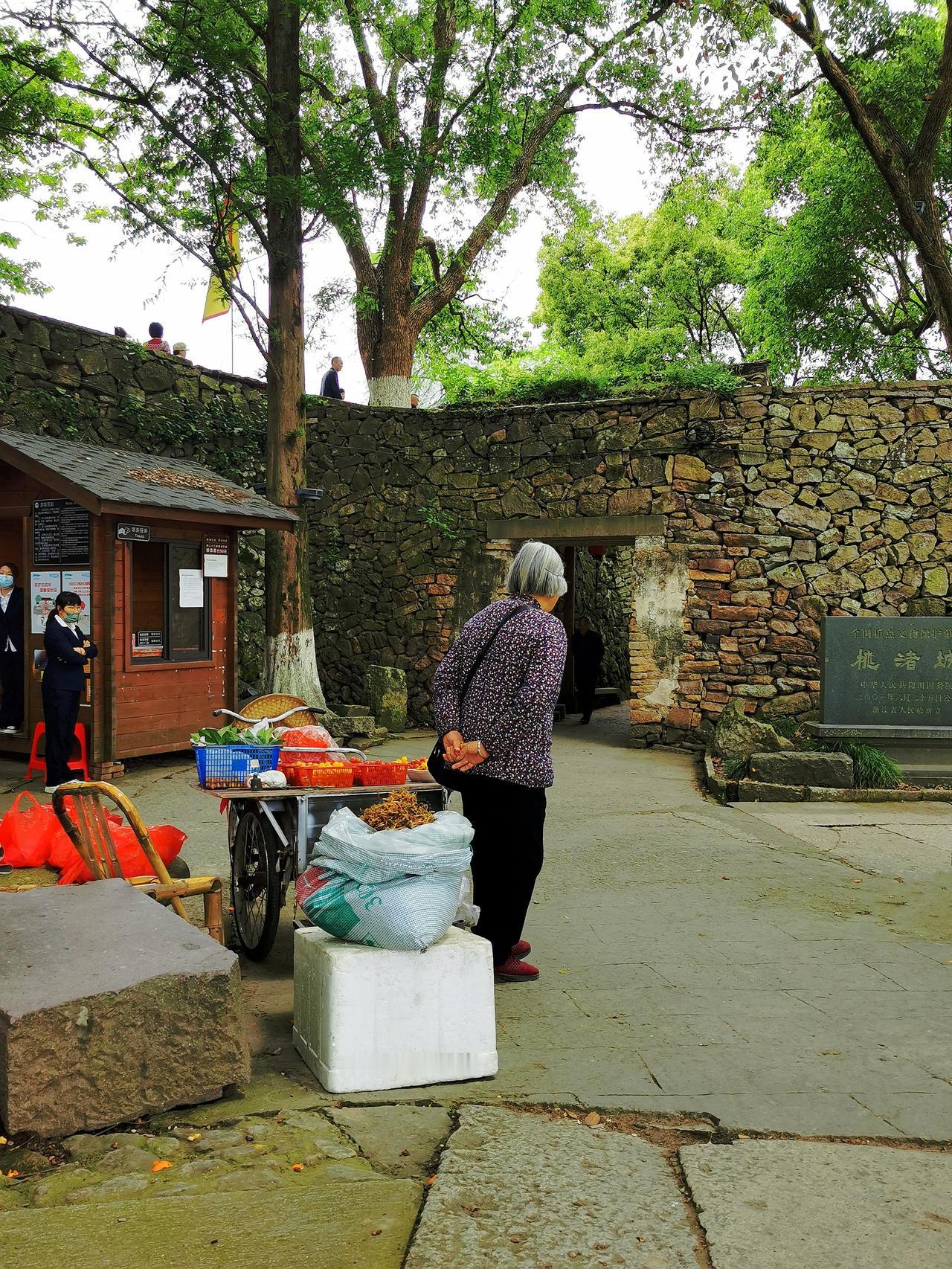 《望眼欲穿》：乡村景点出入口，农妇摆地摊卖山货。人来人往，却无人问津。她们早出晚