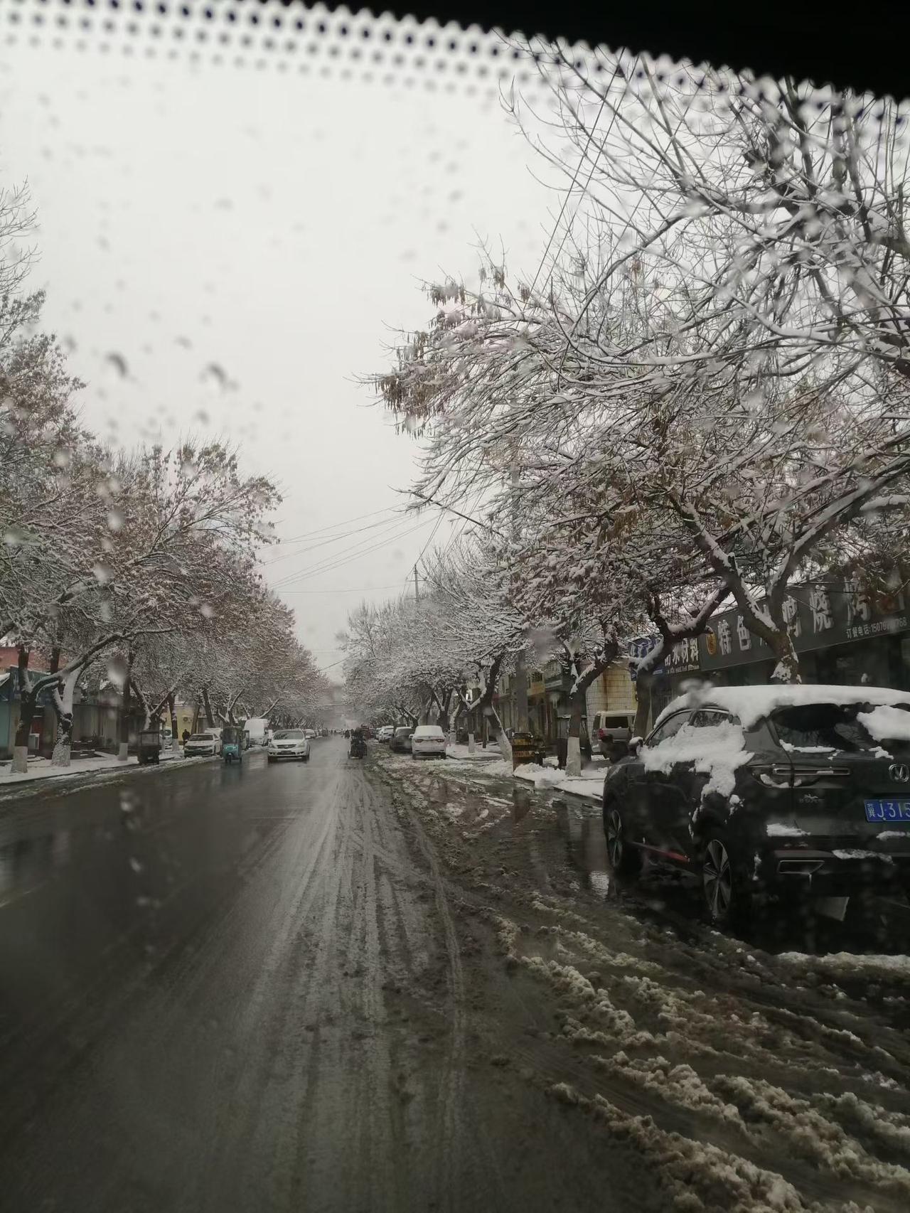 昨天的大雪，还没有化完，铲车把机动车道和非机动车道上的积雪推到路两边，形成了两道