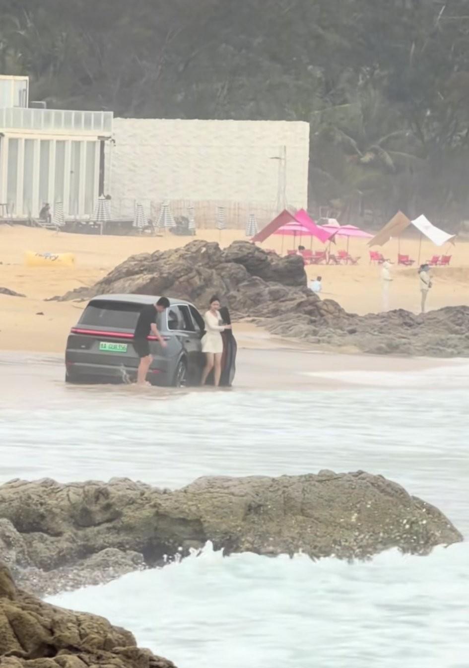 海南。男子开理想带着一个美女在海边耍帅，不想就这么陷在沙滩上出不来了，一开始是自