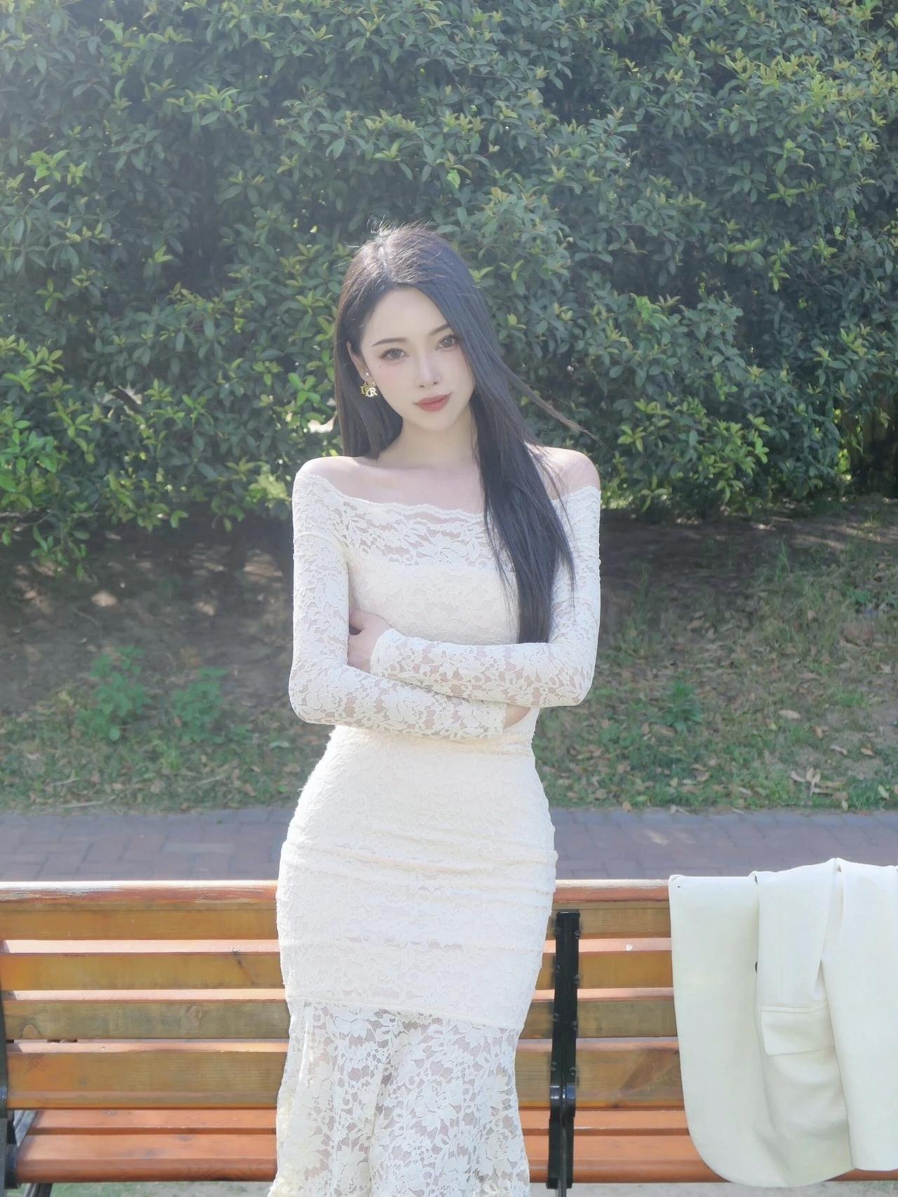 在公园里，优雅蕾丝长裙总能让少女成为焦点。就像街拍里穿白色蕾丝挂脖裙的小姐姐，纯