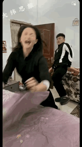 一女子正在弯腰整理床铺，男子从门外走进来，兴奋地在身后抱住了女子，兴奋地说了句：