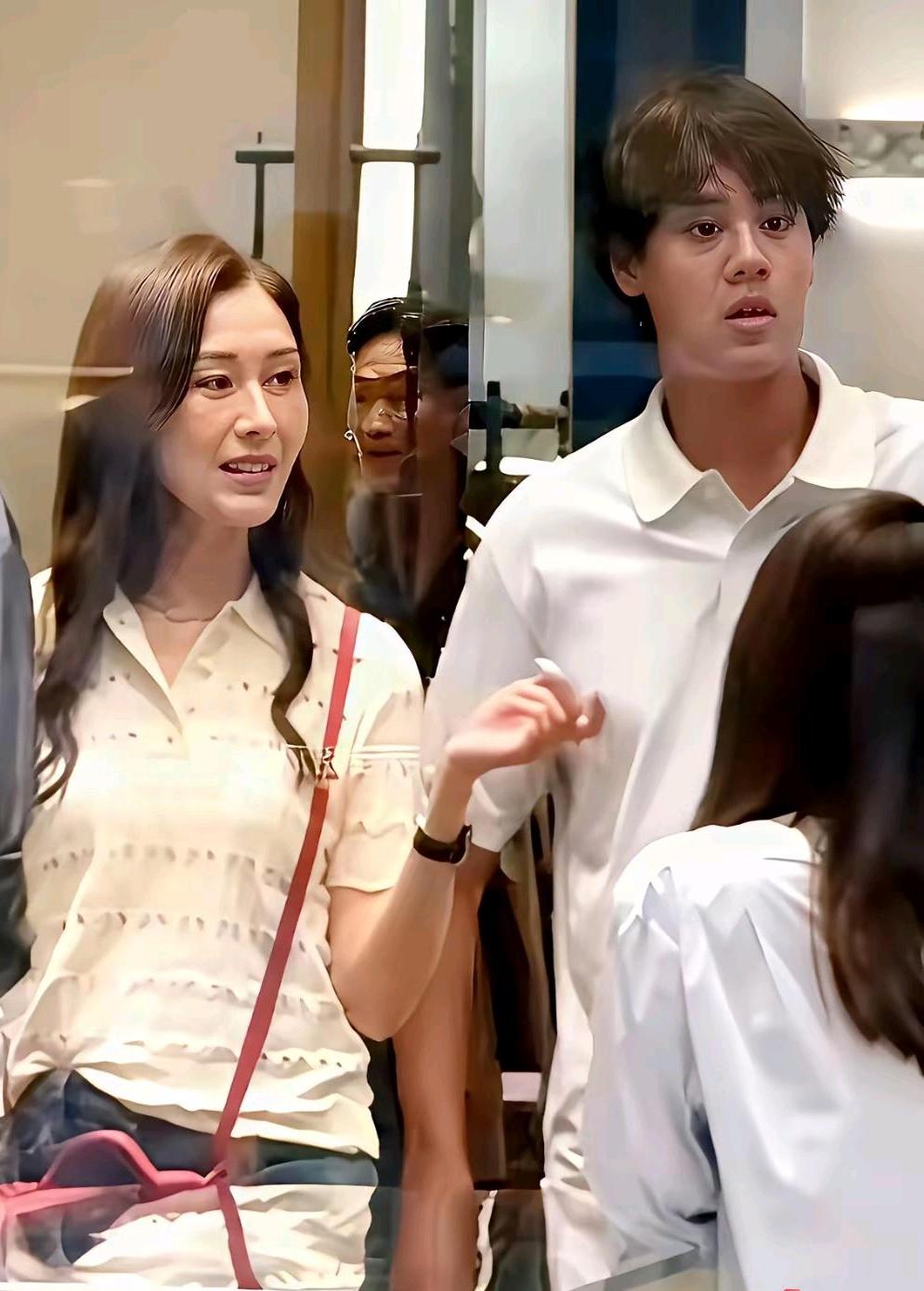 这是李嘉欣与儿子许建彤逛街时被路人偶遇拍下的场景：镜头中56岁的李嘉欣纤秾合