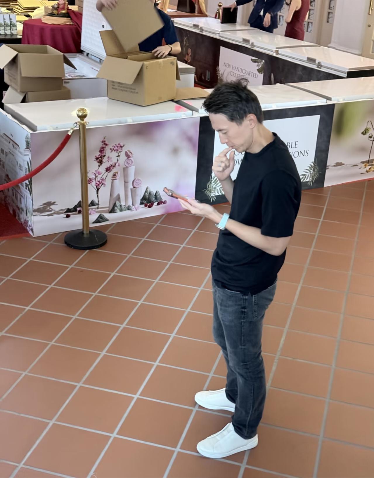 43岁TikTok总裁周受资在新加坡一间酒店大堂被偶遇，他站在过道上看手机，时不