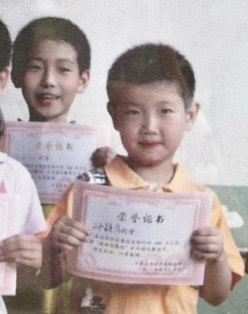 小时候奖状拿到手软。原来莎莎小时候就是短头发，干净利索。拿到奖状和同学合影。双