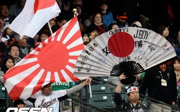 日本球迷在世界杯看台上，挥舞代表军国主义的旭日旗，还让不懂含义的墨西哥球迷，在脸