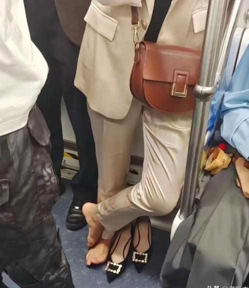 地铁上刷到这一幕，我直接看愣了！好好的尖头高跟鞋被脱在一边，女生光脚踩在车厢地板