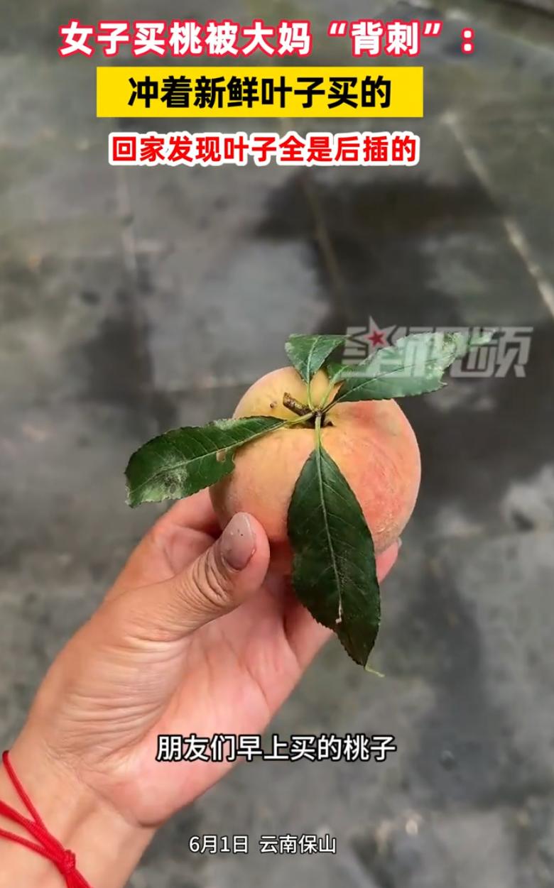 真的防不胜防！云南保山，一名女子逛市场，看着摊位上一位大妈卖的桃子挂满绿叶，看着