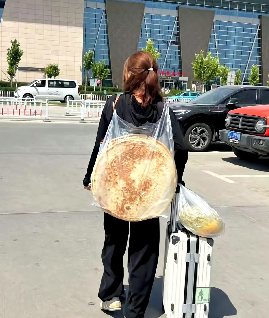 在深圳火车站，看见一个妹子背着两个大饼​​​