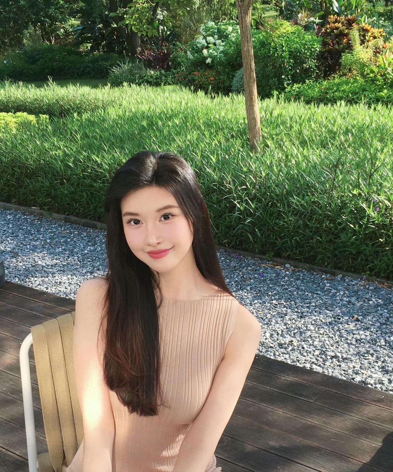 阳光明媚的午后，坐在花园里的少女，微笑着享受美好时光。