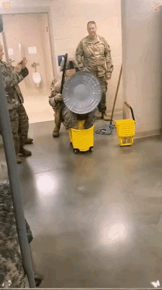 美国大兵闲的没事，也玩起了这种小孩子才玩的游戏，两个人各自坐在一个桶上，一手拿着