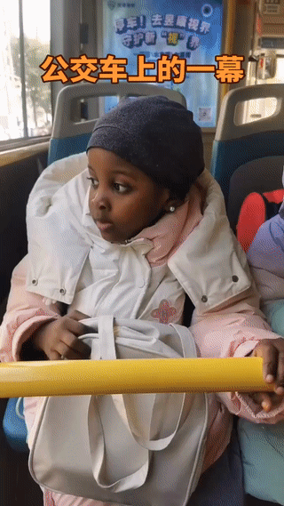 甘肃兰州公交车上。有网友拍到两名黑人双胞胎儿童背着书包乘车上学。其中有一个小