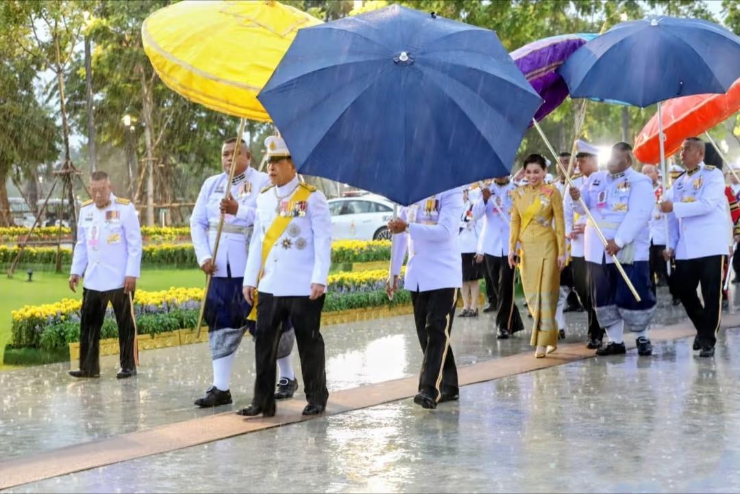 10月13日，苏提达王后和老公玛哈国王在雨中出席活动，苏提达王后依然笑容甜美。