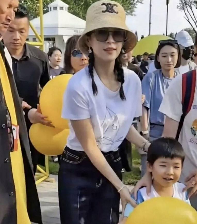 章子怡带着4岁儿子去参加活动，可大方啦，都没给儿子挡脸。那小家伙模样超可爱，吸引