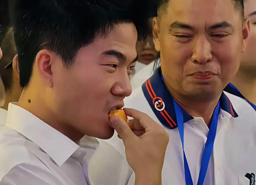 董宇辉这一吃，火爆出圈。在如此正式的场合，身着白色上衣的嘉宾们，在展厅里听着讲