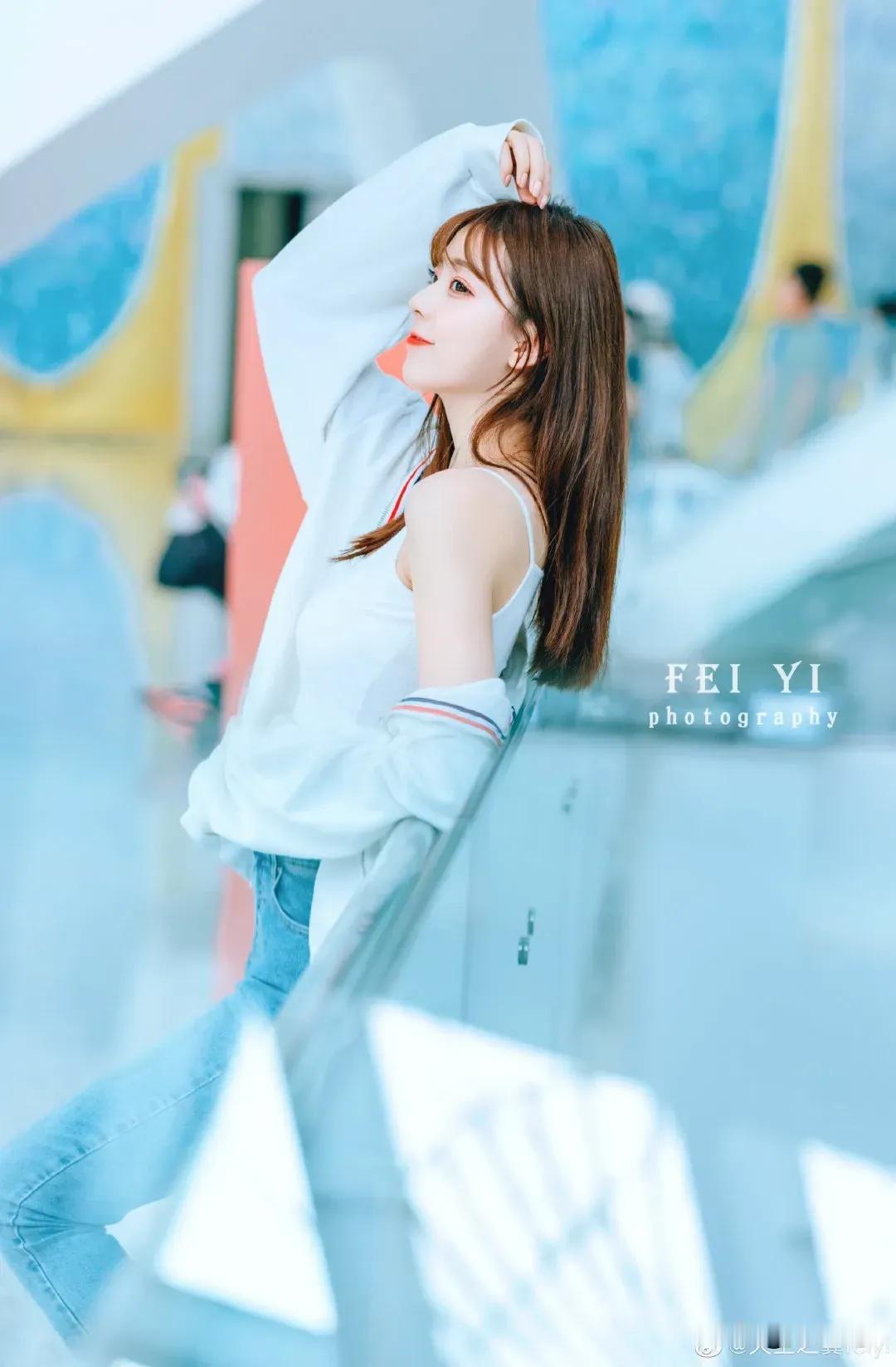 阳光明媚的午后，少女在现代建筑前摆出甜美姿势，FEIYI摄影。春晓写真[给力