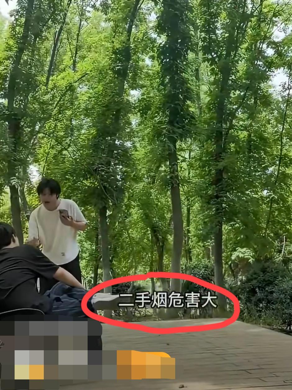 男子在森林公园的椅子上抽烟遭到一旁的白衣男子训斥:“二手烟危害大，不要在这里抽了