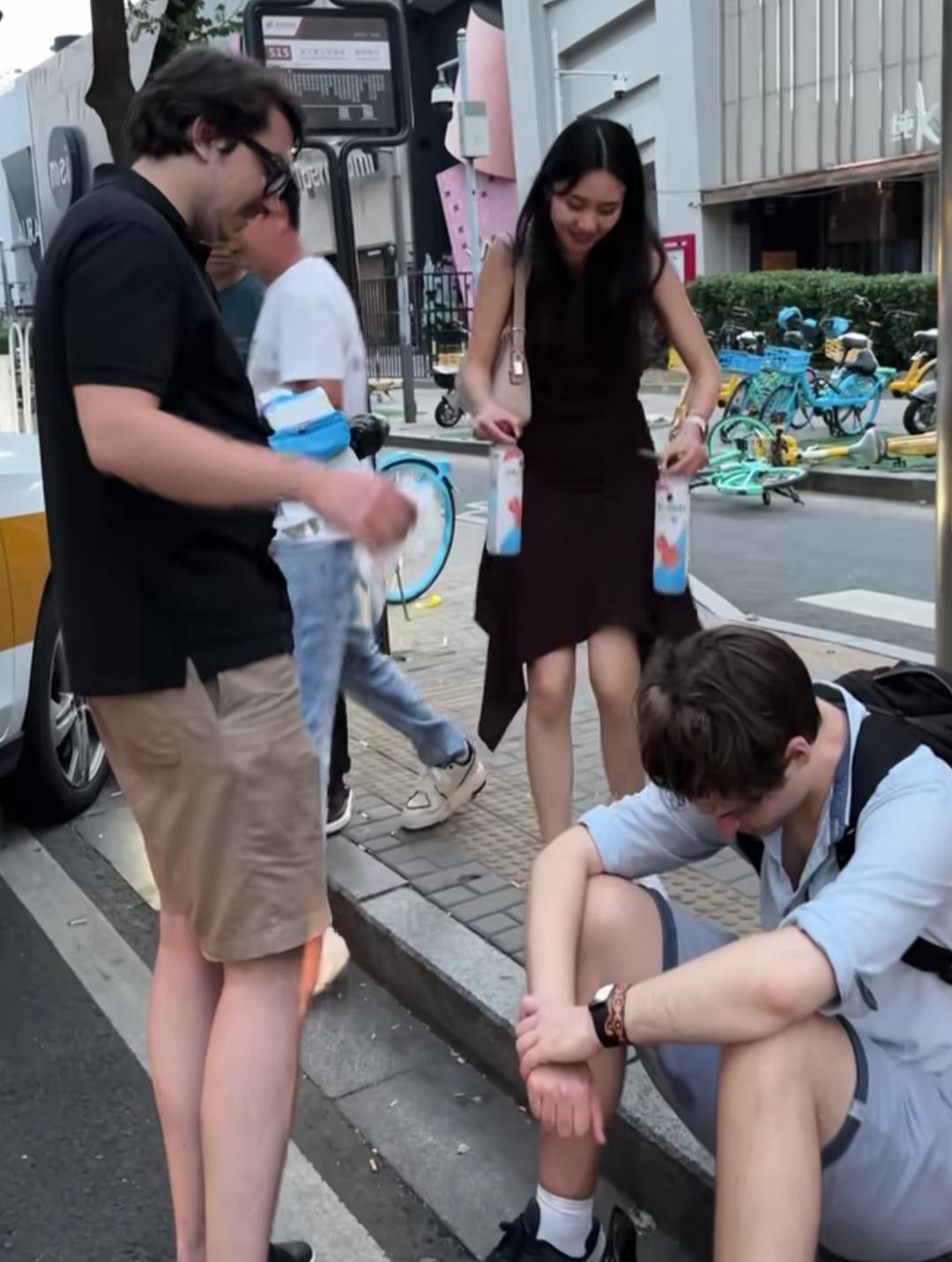 公交车站这一幕，看得人心里真不是滋味。两个外国人可能遇到了什么困难，坐在台阶上神