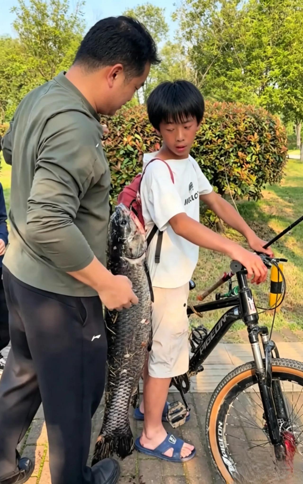 这不是炫耀，是一个孩子最珍贵的骨气他扛的不是鱼，是不轻易低头的少年气。看