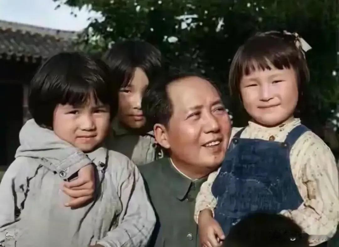 李讷阿姨小时候的模样好可爱，穿着深色背带裤，剪短发，坐在父亲怀中，抿着小嘴微笑着