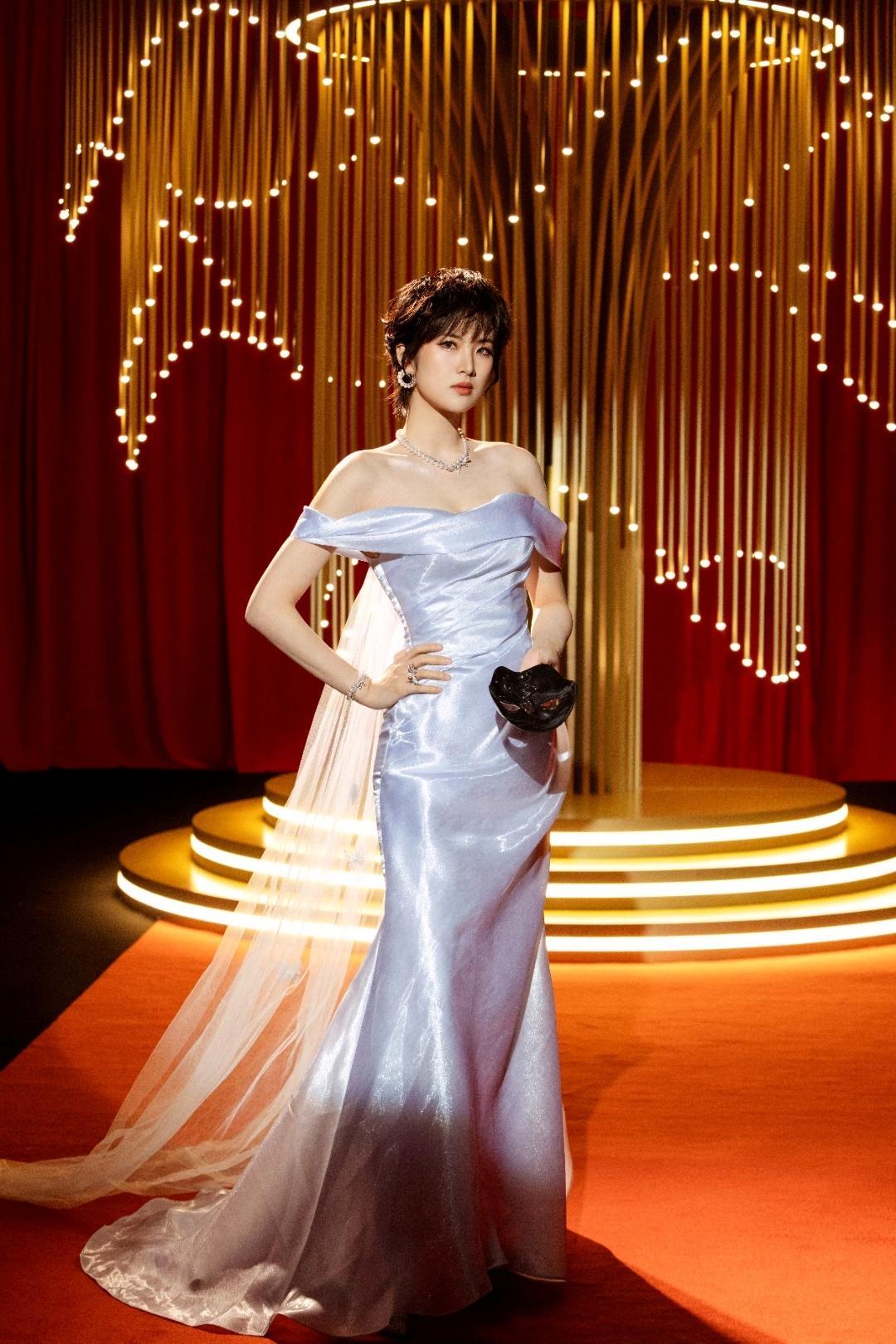 姚安娜一袭冰蓝色露肩鱼尾裙摇曳于红毯，流光面料在暖光下泛着细腻光泽，薄纱拖尾轻拂