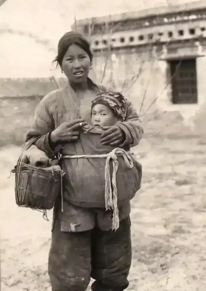 民国时期，一位带着孩子逃难的妇女，在寒冷冬天，将孩子塞在自己衣服里，用自己的体温