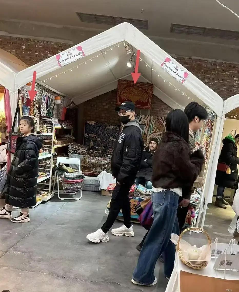 汪峰牵着醒醒在798市集里挑T恤，四件加起来不到五百块，他蹲着帮女儿翻尺码，像极