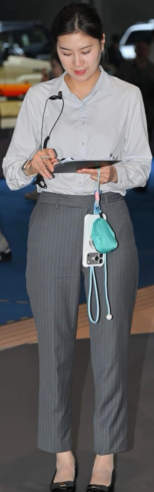浅灰长袖衬衫搭配灰色竖条纹九分西裤，利落版型修饰线条，配上低跟黑皮鞋，干练大方，