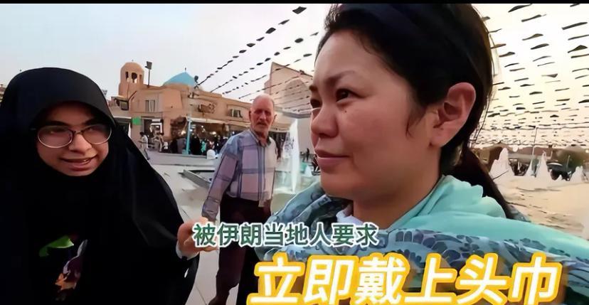 两位华人女子在伊朗大街上被一位黑衣女子要求，让她戴头巾。一开始黑衣女子很客气，笑
