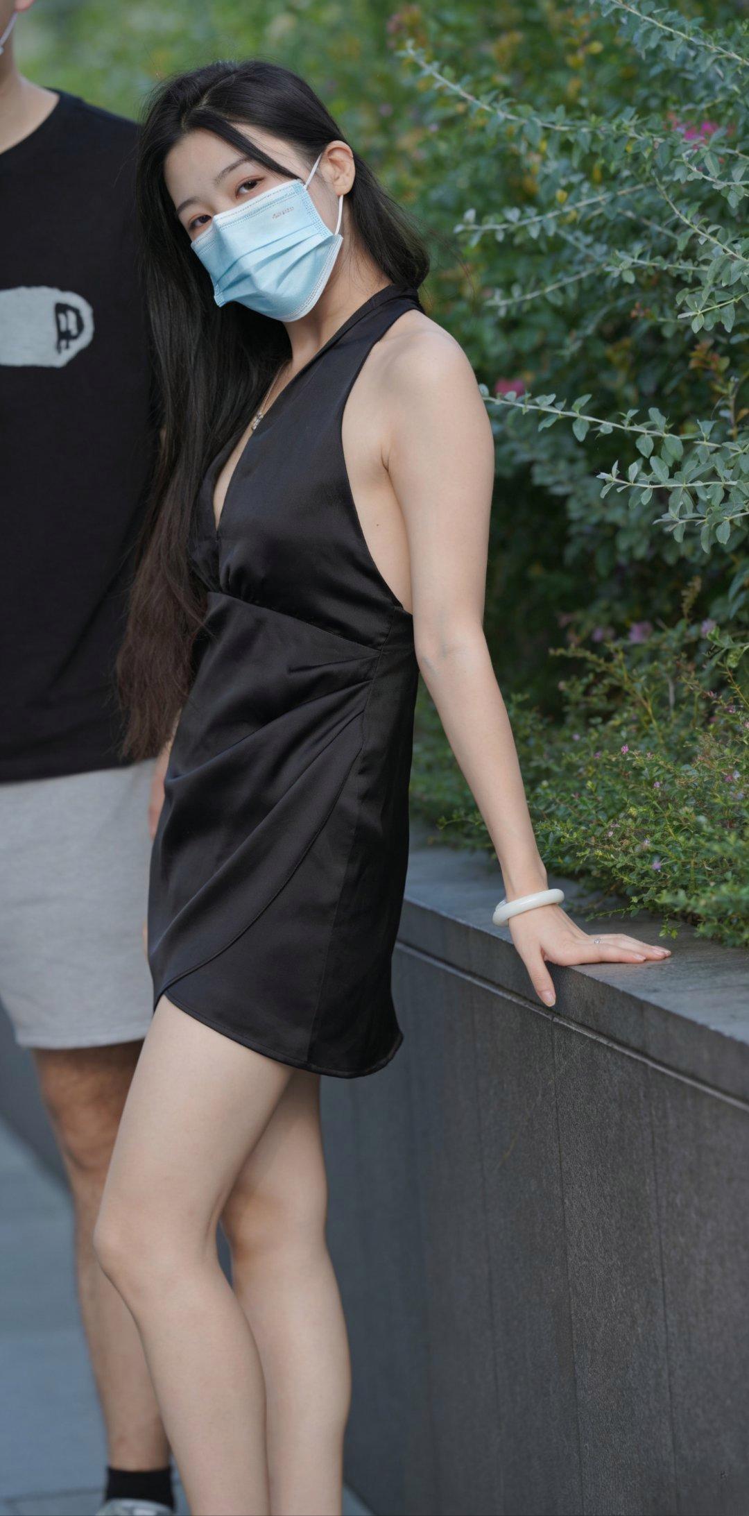 夏日街头的氛围感，被这位姐姐狠狠拿捏。一袭黑色缎面挂脖短裙，丝滑的面料带高级