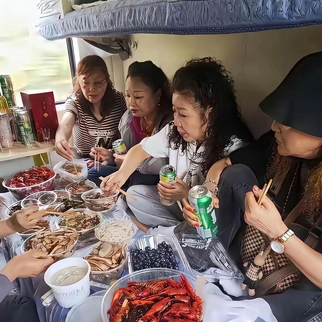 大伙看看，在火车车厢摆这么一大桌吃喝合适吗？几位朋友在卧铺车厢，铺好了东西