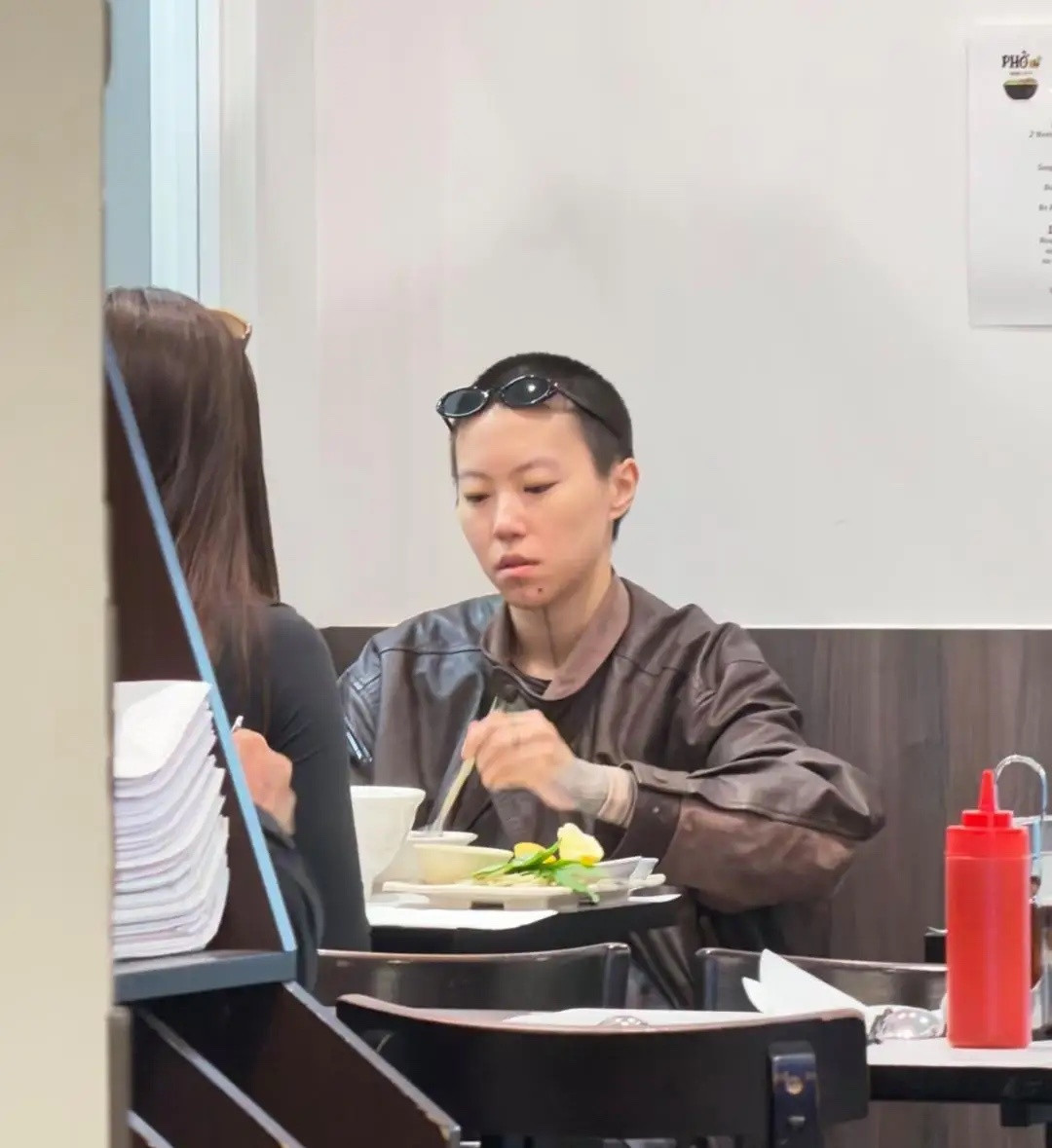 窦靖童在法国巴黎一家餐馆吃汤面被偶遇，她留着寸头短发，下巴刺了纹身，中性打扮非常