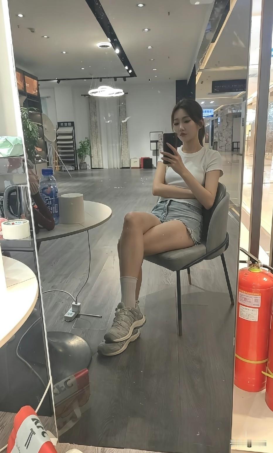 一个人坐在店里玩手机。