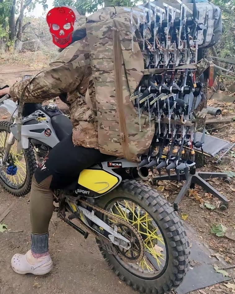 俄军士兵骑着摩托运送着无人机，现在无人机在战场上可是抢手货啊，俄军士兵很多人都希